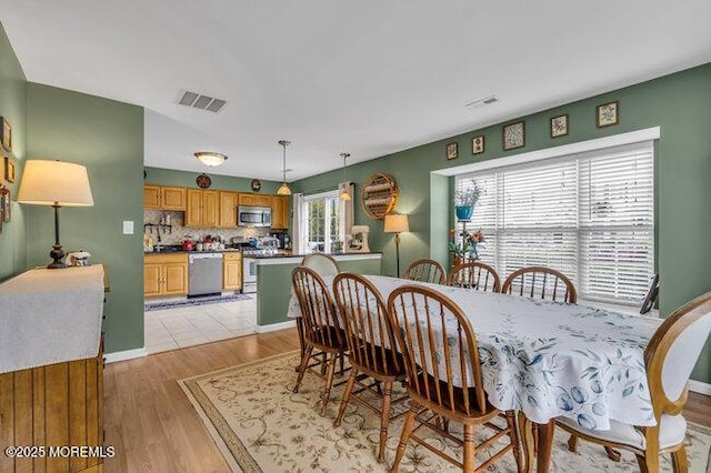 dining space featuring visible vents and light wood finished floors