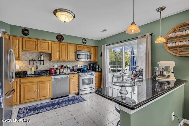 kitchen featuring backsplash, stainless steel appliances, visible vents, and hanging light fixtures