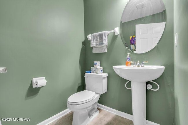 bathroom featuring tile patterned flooring, baseboards, and toilet
