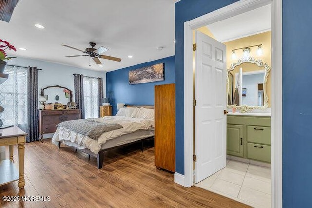 bedroom with ensuite bath, a ceiling fan, recessed lighting, and light wood-style flooring