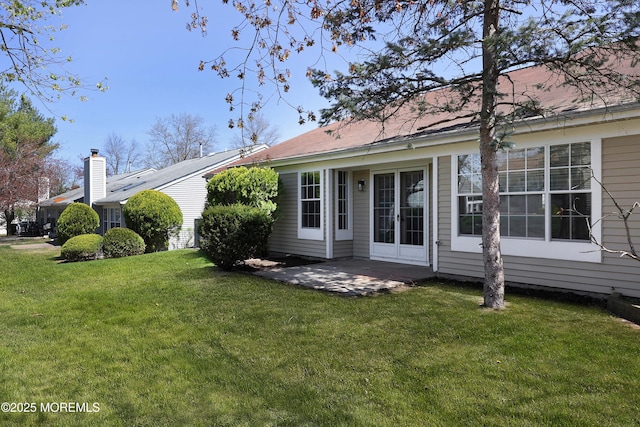 rear view of house featuring a lawn and a patio area