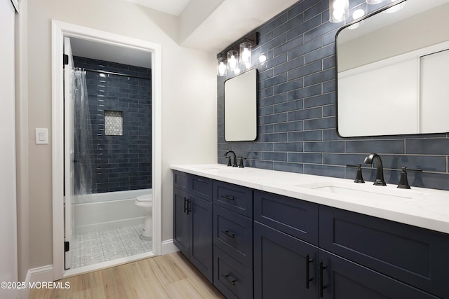 full bathroom with double vanity, baseboards, decorative backsplash, and a sink