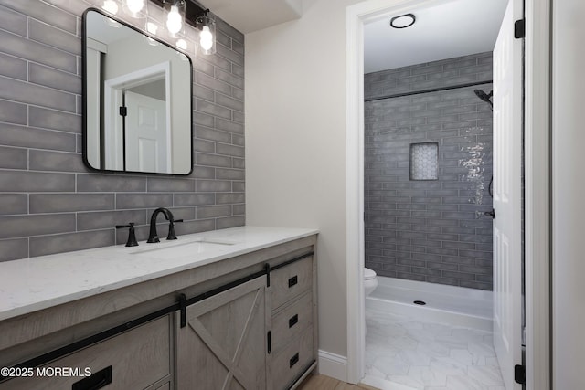 bathroom with vanity, a shower stall, tasteful backsplash, and toilet