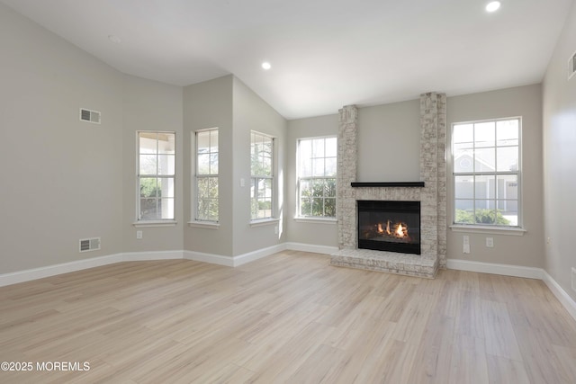 unfurnished living room with plenty of natural light, wood finished floors, and visible vents