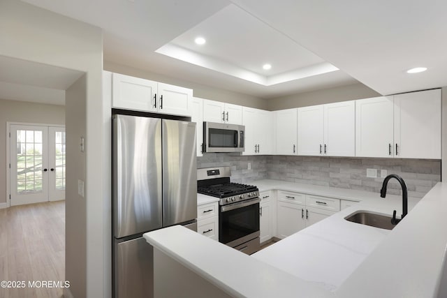 kitchen featuring stainless steel appliances, a sink, light wood-type flooring, recessed lighting, and decorative backsplash