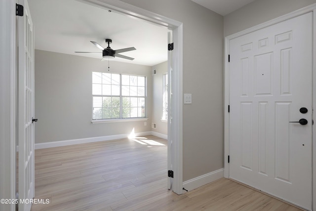 entrance foyer featuring baseboards, a ceiling fan, and light wood-style flooring