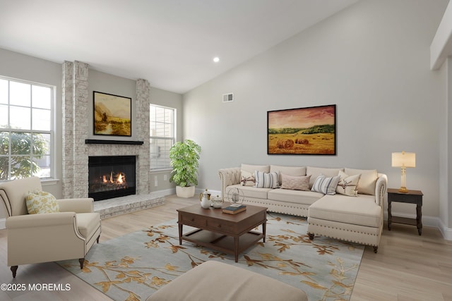 living area with plenty of natural light, visible vents, light wood finished floors, and baseboards
