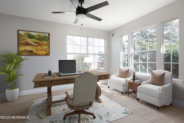 home office with baseboards, a ceiling fan, light wood-style floors, and visible vents