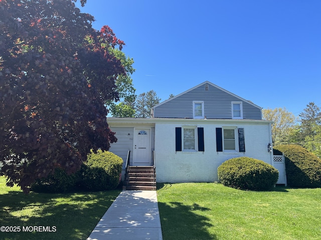 view of front of house featuring a front lawn, brick siding, and entry steps