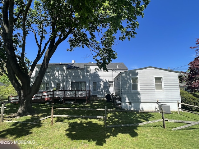 rear view of house featuring fence, a yard, cooling unit, and a deck