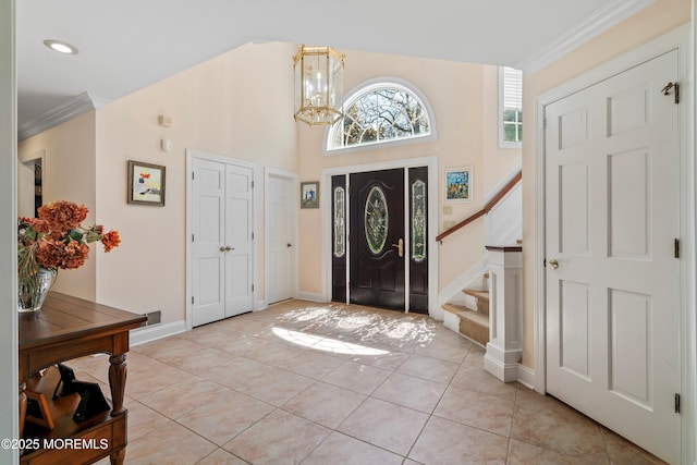 entryway with stairs, ornamental molding, and light tile patterned floors