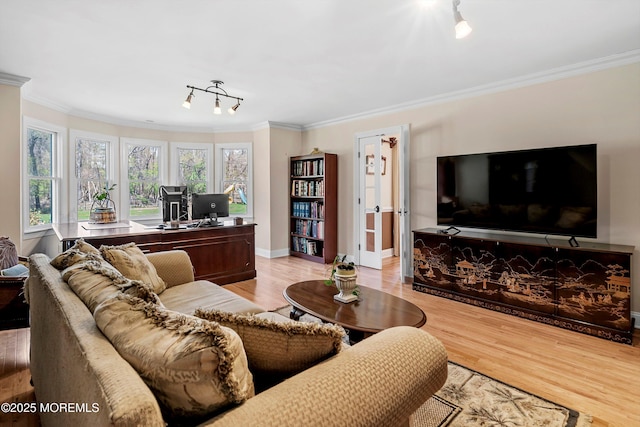 living area with light wood-type flooring, baseboards, and ornamental molding