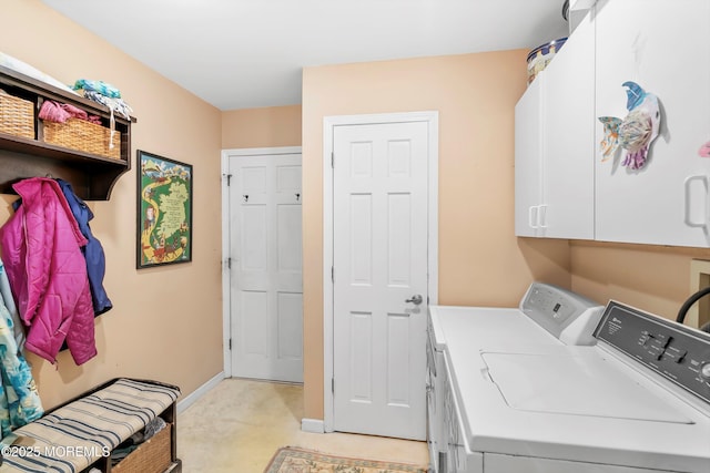 laundry area with light colored carpet, separate washer and dryer, baseboards, and cabinet space