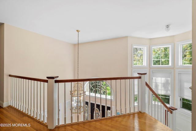 hallway featuring wood finished floors and an upstairs landing