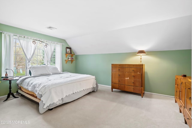 carpeted bedroom with lofted ceiling, baseboards, and visible vents