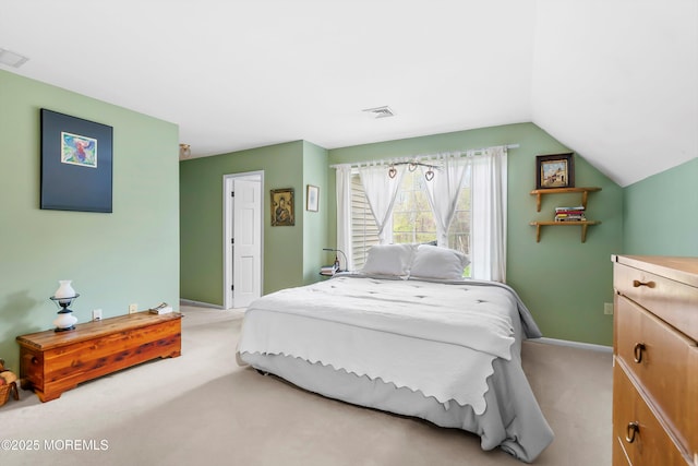 bedroom featuring baseboards, vaulted ceiling, visible vents, and light colored carpet