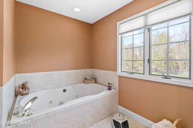full bathroom featuring baseboards, a whirlpool tub, and tile patterned flooring