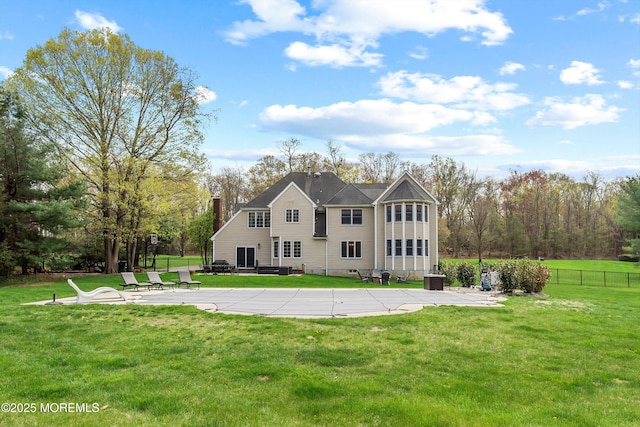 view of front of house featuring fence, a front lawn, a chimney, and a patio