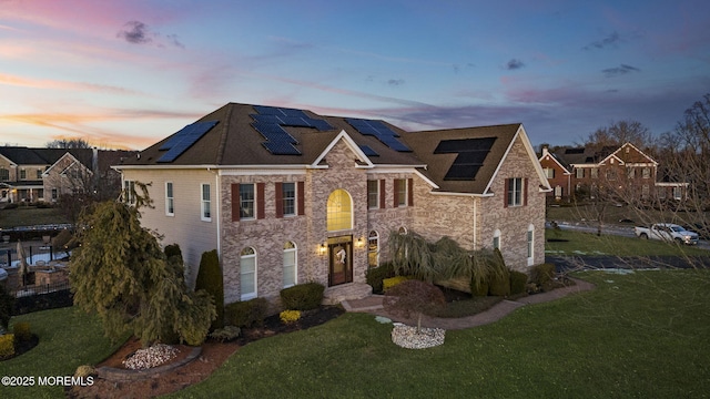 5 Courtney Ct, Freehold, NJ 07728 - view of front facade with roof mounted solar panels, stone siding, and a front yard