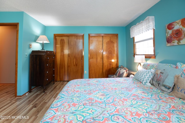 12 Millstream Rd, Cream Ridge, NJ 08514 - bedroom with wood finished floors, two closets, a textured ceiling, and baseboards