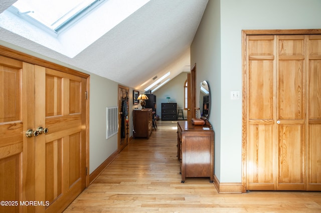 12 Millstream Rd, Cream Ridge, NJ 08514 - hall with lofted ceiling with skylight, baseboards, light wood-type flooring, and visible vents