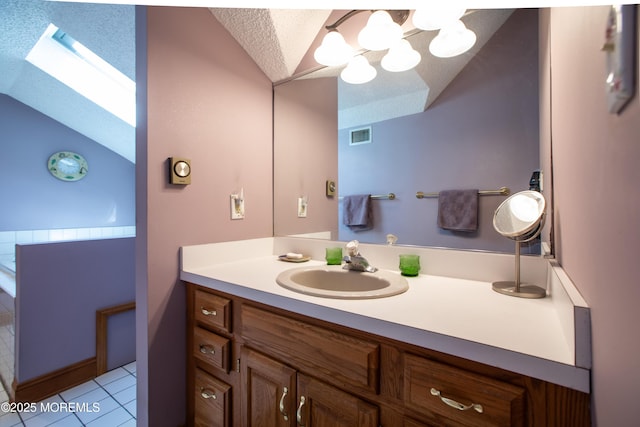 12 Millstream Rd, Cream Ridge, NJ 08514 - bathroom with lofted ceiling, a skylight, vanity, tile patterned floors, and a textured ceiling
