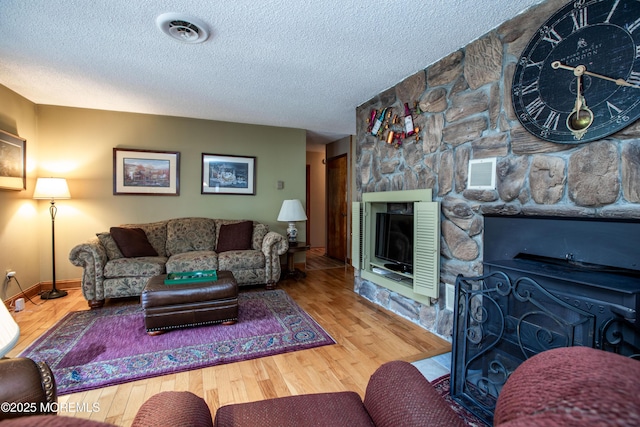 12 Millstream Rd, Cream Ridge, NJ 08514 - living area featuring a textured ceiling, visible vents, a fireplace, and wood finished floors