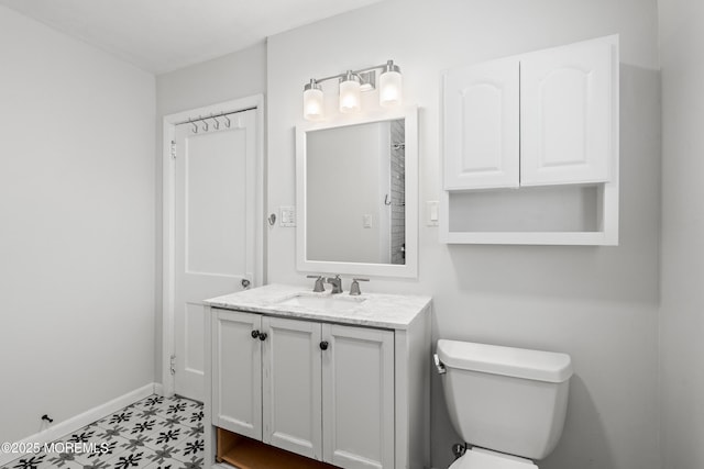 bathroom with vanity, baseboards, tile patterned floors, and toilet