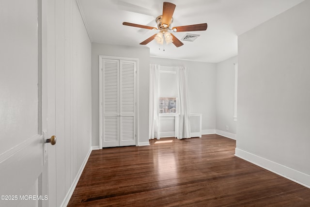 unfurnished bedroom with a ceiling fan, baseboards, visible vents, and wood finished floors
