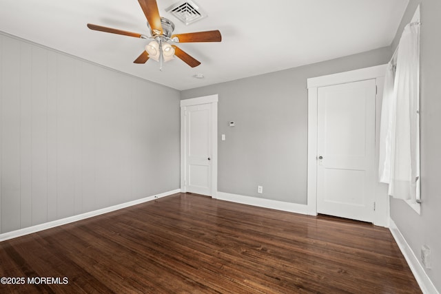 unfurnished bedroom with baseboards, ceiling fan, wood finished floors, and visible vents