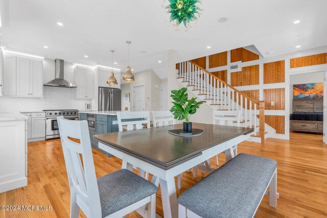 dining space featuring stairway, light wood finished floors, and recessed lighting