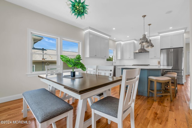 dining space with baseboards, light wood-style floors, and recessed lighting