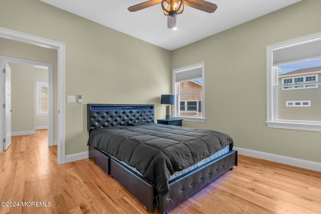 bedroom with baseboards, light wood-style floors, and multiple windows
