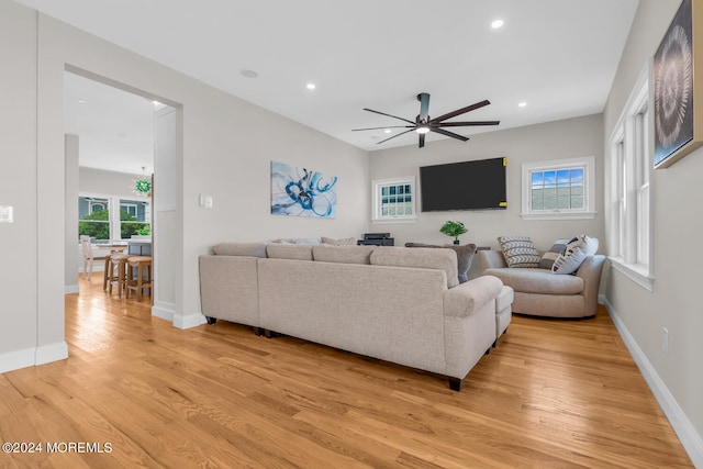 living area with baseboards, a ceiling fan, light wood finished floors, and recessed lighting
