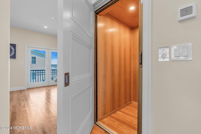 room details featuring wood finished floors, french doors, elevator, baseboards, and recessed lighting