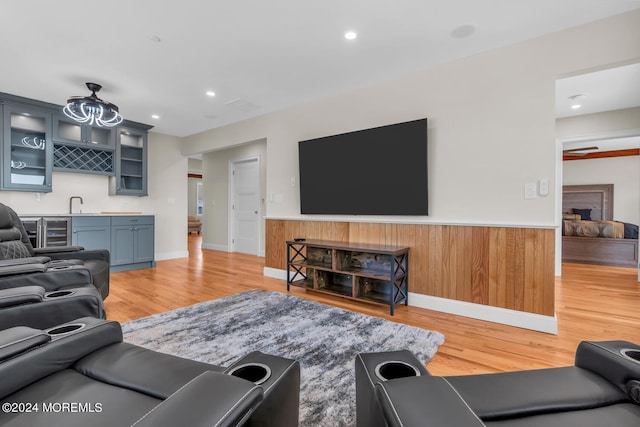 living area with wet bar, light wood-style flooring, wainscoting, and wine cooler