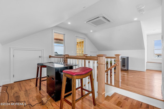bonus room featuring lofted ceiling, wood finished floors, visible vents, and baseboards