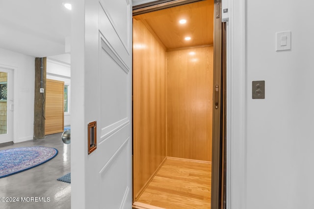 room details with baseboards, elevator, finished concrete floors, and recessed lighting
