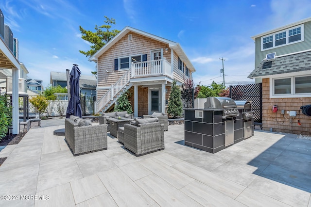 view of patio featuring grilling area, stairway, an outdoor living space, and fence
