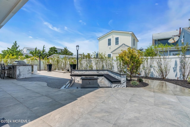 surrounding community featuring exterior kitchen, a patio area, and a fenced backyard