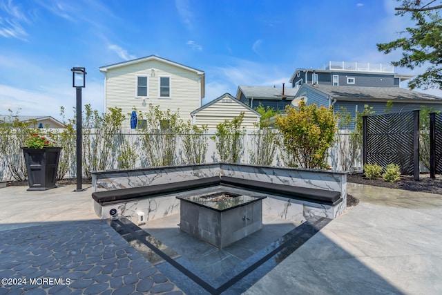exterior space featuring an outdoor fire pit and fence