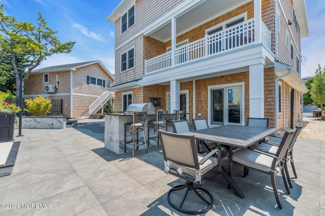 view of patio featuring exterior kitchen, outdoor dining space, a balcony, and exterior bar