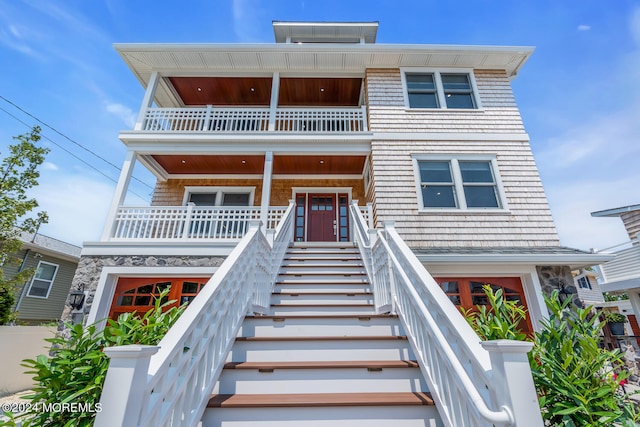 view of front of house featuring stairway, covered porch, and a balcony