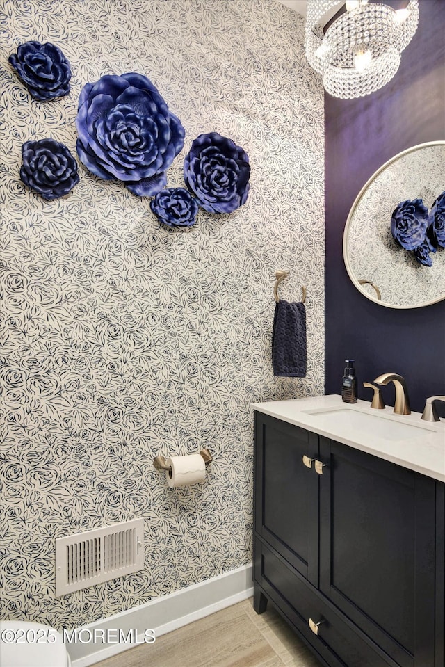 105 Pilot St, Marlboro, NJ 07746 - bathroom featuring baseboards, visible vents, a notable chandelier, wallpapered walls, and vanity