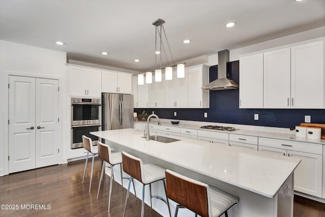 105 Pilot St, Marlboro, NJ 07746 - kitchen with a sink, a breakfast bar, stainless steel appliances, white cabinets, and wall chimney exhaust hood