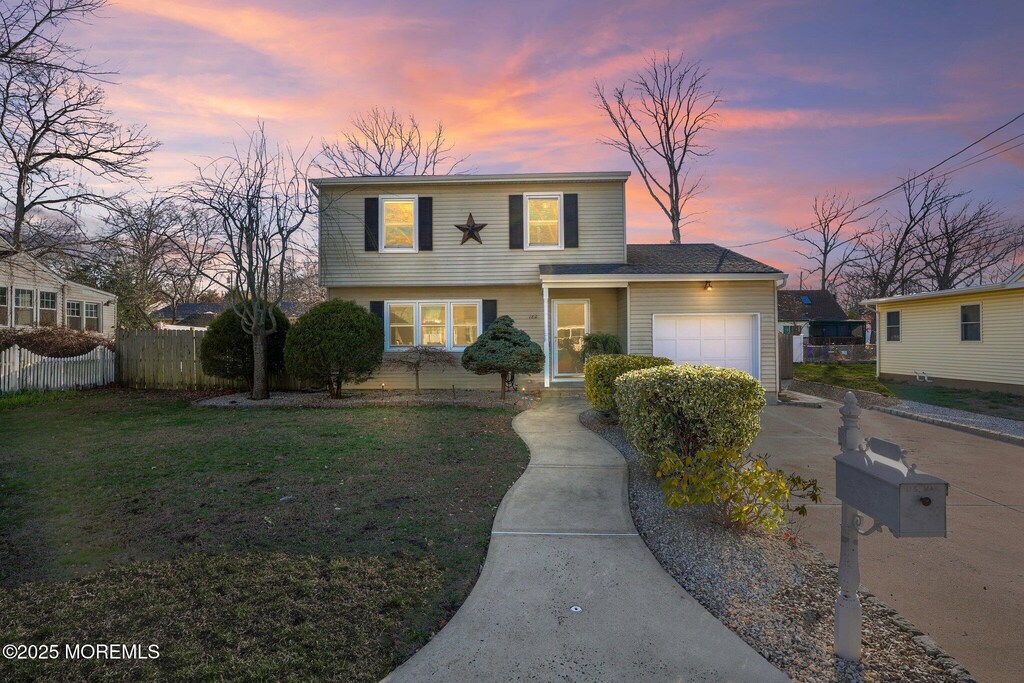 180 Mckinley Ct, Brick, NJ 08724 - traditional-style house with an attached garage, a front lawn, driveway, and fence