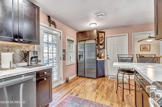 627 Huntington Dr Unit C, Lakewood, NJ 08701 - kitchen featuring appliances with stainless steel finishes, light wood-type flooring, light stone countertops, dark brown cabinets, and tasteful backsplash