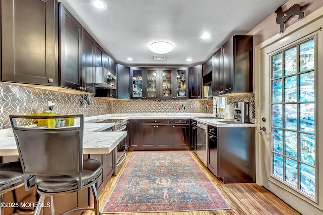 627 Huntington Dr Unit C, Lakewood, NJ 08701 - kitchen featuring a sink, stainless steel appliances, light countertops, glass insert cabinets, and light wood-style flooring
