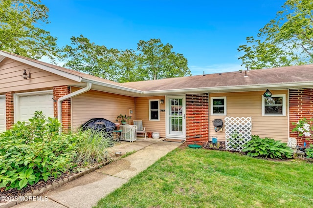 627 Huntington Dr Unit C, Lakewood, NJ 08701 - view of exterior entry with brick siding, a yard, an attached garage, central AC, and roof with shingles