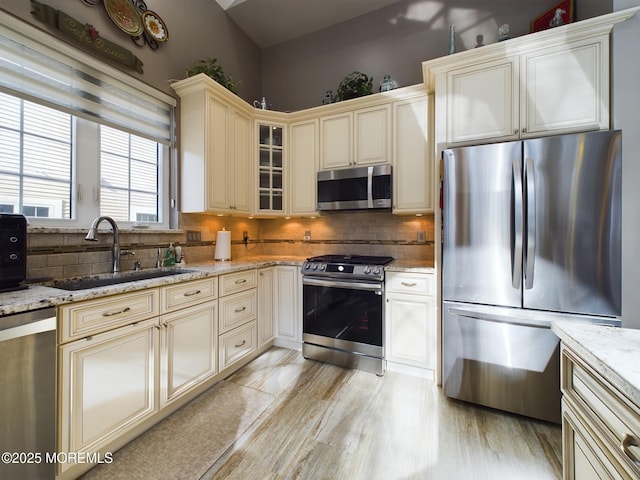 89 Pebble Beach Blvd, Jackson, NJ 08527 - kitchen with stainless steel appliances, cream cabinets, a sink, light stone countertops, and tasteful backsplash